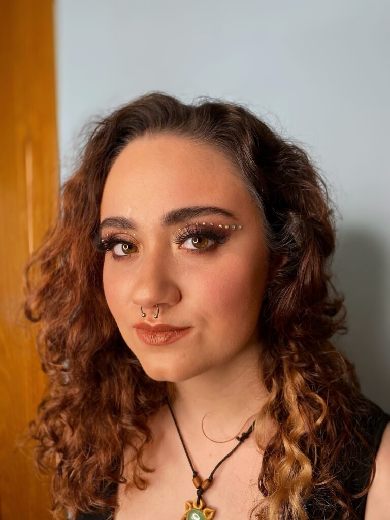 Sombra de ojos burdeos con eyeliner gráfico de brillos, maquillaje estilo euphoria, pestañas postizas, maquillaje con aerógrafo