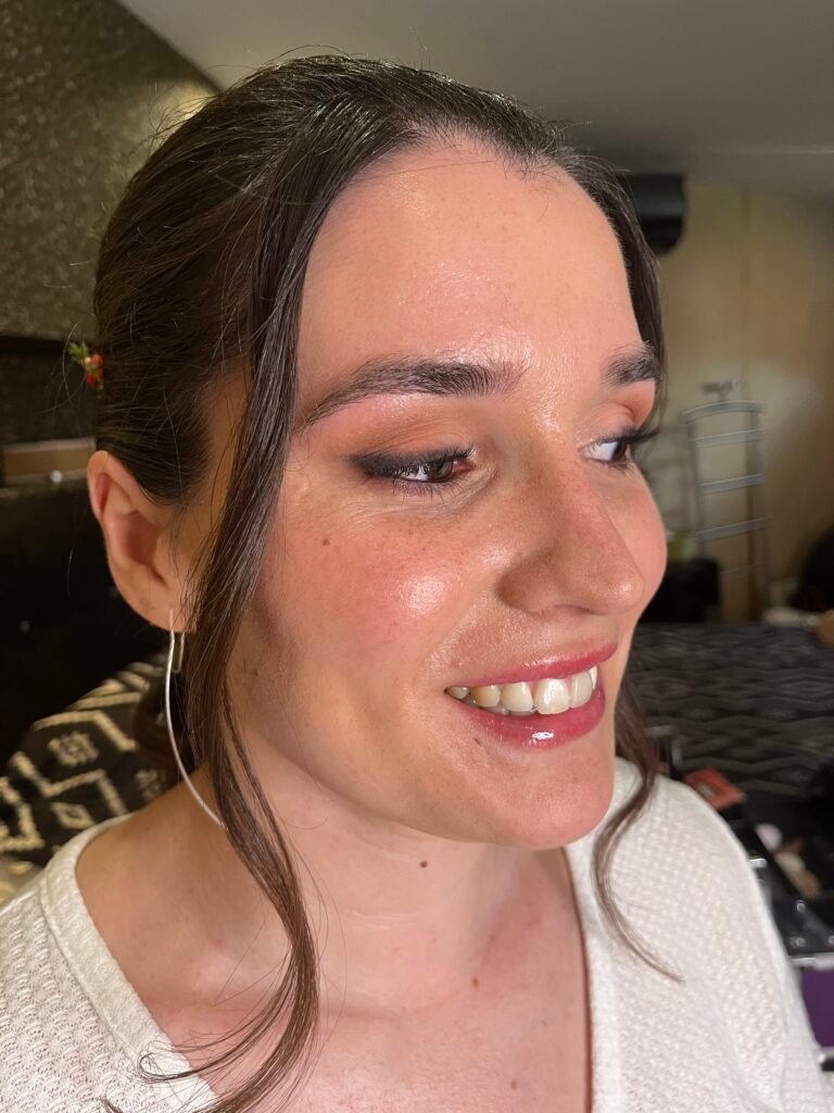 Maquillaje de novia con piel jugosa, brillo de labios y sombra de ojos natural.